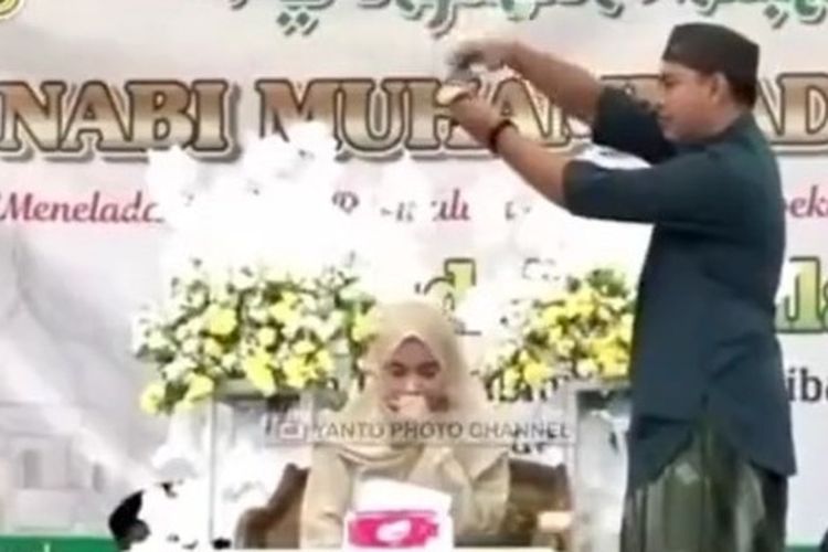 Seorang pria menyawer qoriah Nadia Hawasy dengan cara menaburkan uang (foto: Kompas.com)