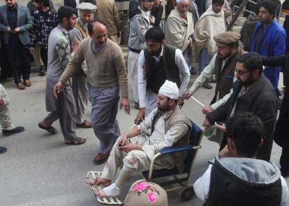 Orang-orang membawa korban terluka akibat ledakan bom bunuh diri di masijd di Peshawar, Pakistan (Reuters)