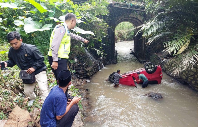 Honda Jazz P 1131 GC terjun ke sungai di Kelurahan Kebonagung, Kecamatan Kaliwates, Jember. (foto: Radar Jember)