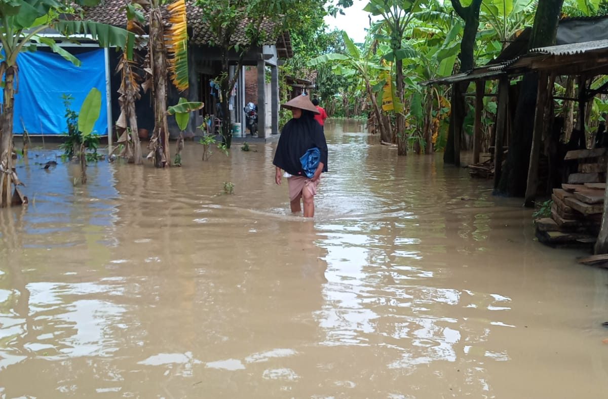 Seorang warga melintasi genangan banjir di Desa Sowan Kidul, Kecamatan Kedung, Kabupaten Jepara pada Kamis (23/02) (Klikfakta/Nur Ithrotul Fadhilah)