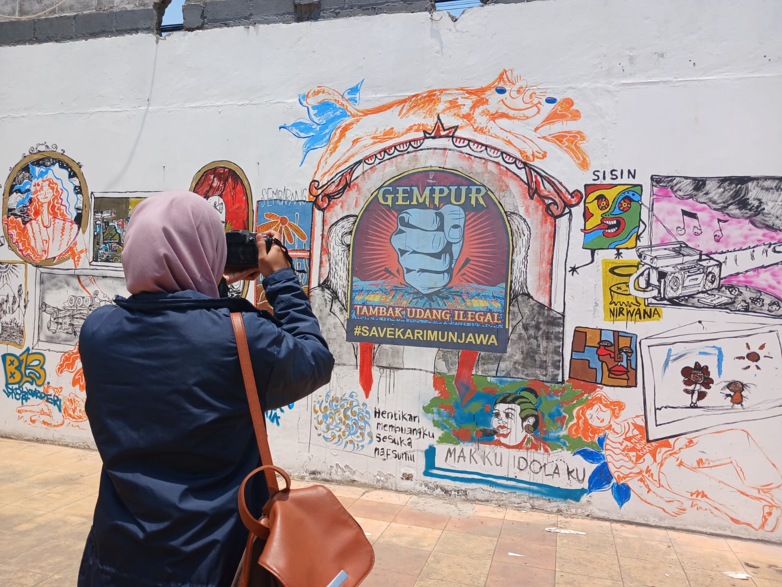 Seseorang tengah memotret mural di Kanal Canter #1 (Klikfakta/Nur Ithrotul Fadhilah)