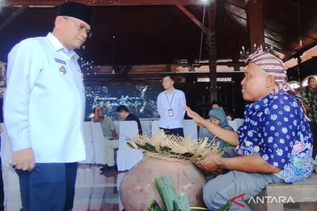 Pj Bupati Kudus M Hasan Chabibie berbincang dengan salah satu pengrajin caping kalo di pameran lukisan potret khazanah budaya dan seni khas Kudus di Pendopo Kabupaten Kudus pada Jumat (26/4/2024) (Foto: ANTARA Jateng)