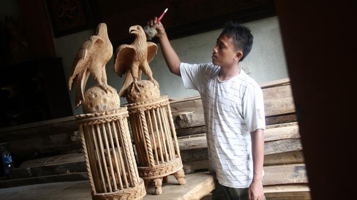 Seorang perajin membersihkan hasil pahat macan kurung yang pembuatannya memiliki tingkat kesulitan tinggi. (tribun jateng/m syofri kurniawan)