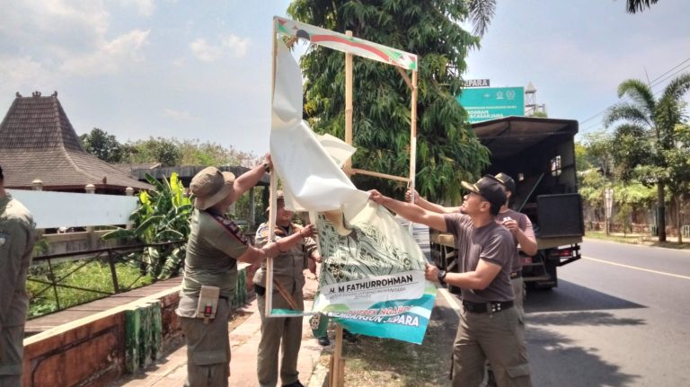 Satpol PP Kabupaten Jepara saat melakukan penertiban baliho di area Jepara Kota, Selasa (8/10/24).