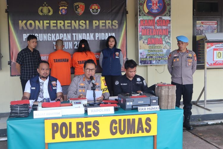 Pasutri tersangka pembuat SIM palsu asal Kudus, Jawa Tengah, berdiri membelakangi dalam konferensi pers yang digelar di Polres Gunung Mas, Kalimantan Tengah, Selasa (5/11/2024). (Kompas.com/DOK. HUMAS POLRES GUNUNG MAS)