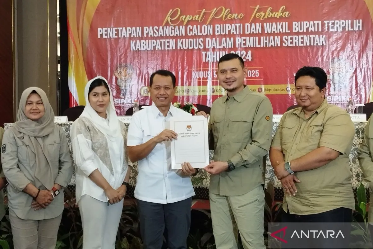 Ketua Komisioner KPU Kudus Ahmad Amir Faisol menyerahkan salinan berkas acara rapat pleno penetapan paslon Bupati dan Wakil Bupati Kudus terpilih kepada Sam'ani Intakoris didampingi Bellinda Putri Sabrina Birton di Kudus, Kamis (9/1/2025). ANTARA/Akhmad Nazaruddin Lathif.