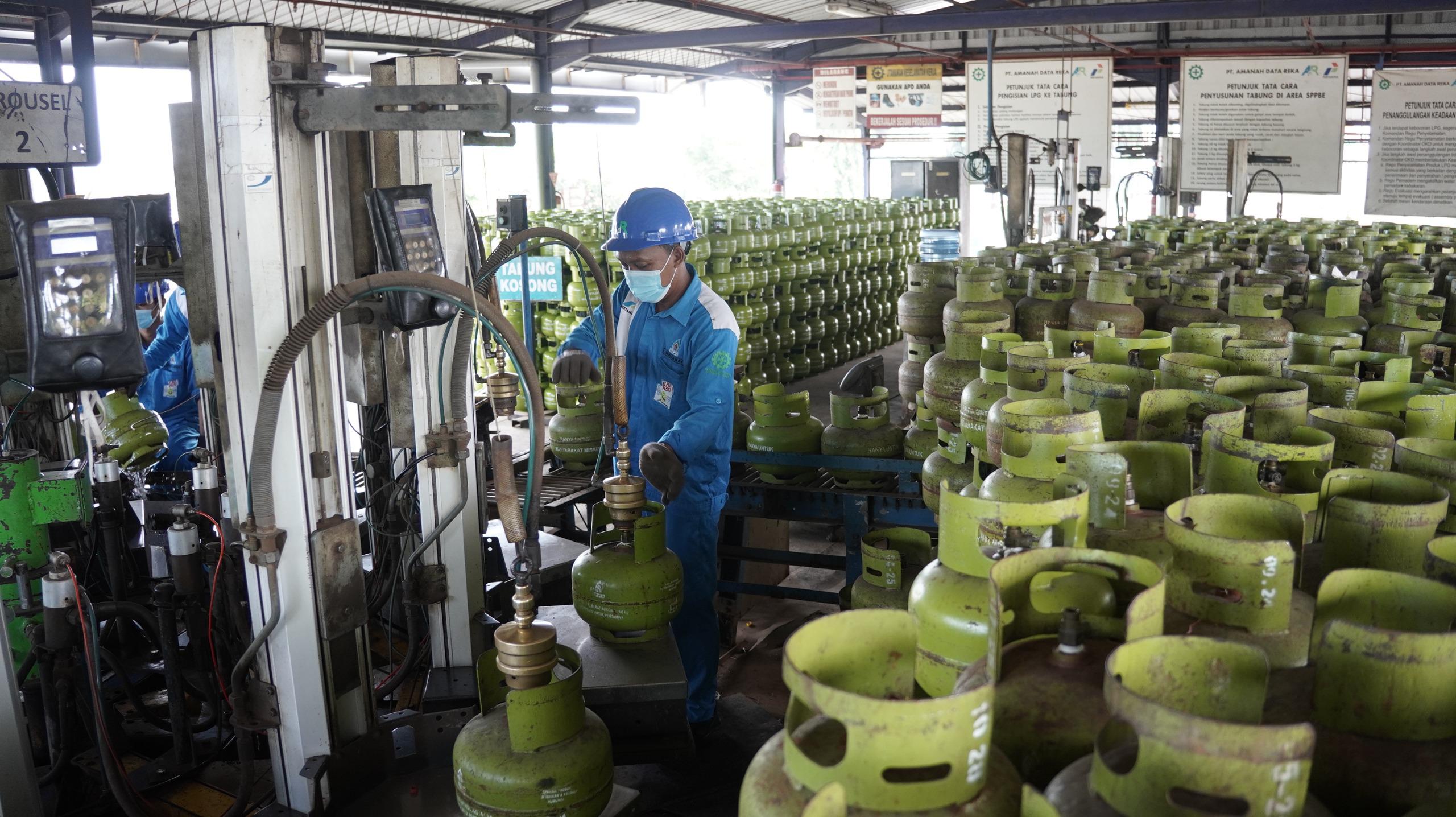 Petugas Pertamina melakukan pengisian tabung gas LPG 3 KG atau melon