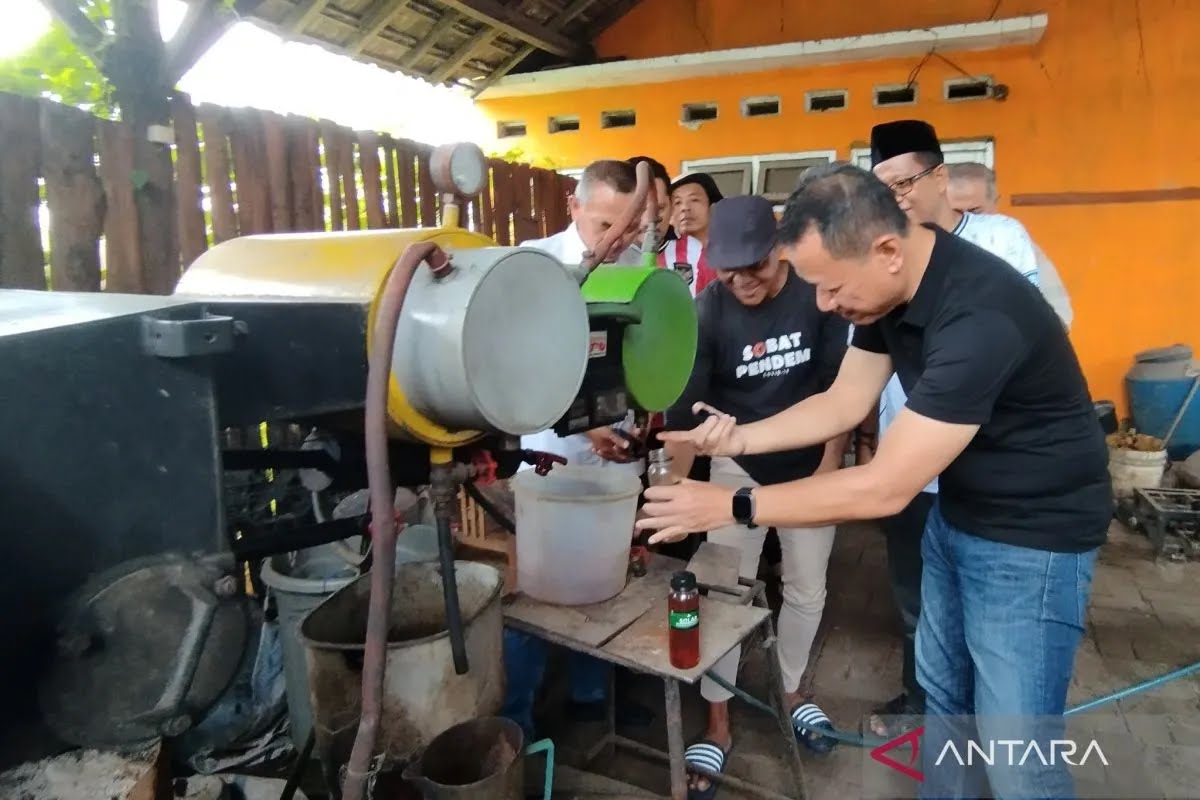 Bupati Kudus Sam'ani Intakoris mencoba menampung BBM hasil pengolahan limbah plastik di tempat pengolahan limbah di Desa Sidorekso, Kecamatan Kaliwungu, Kabupaten Kudus pada Minggu (23/3/2025) (foto:ANTARA)