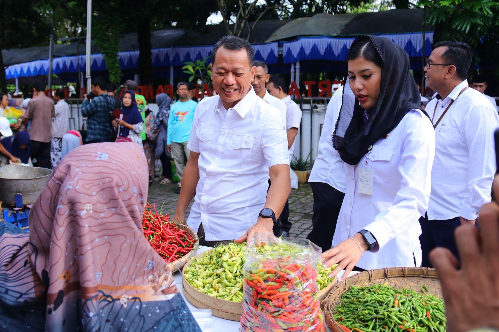 Bupati Kudus Sam'ani Intakoris dengan Wakil Bupati Kudus Bellinda Birton yang hadir ikut mengecek harga sembako di stand-stand pedagang Gerakan Pasar Murah di depan kantor Dinas Pertanian dan Pangan Kabupaten Kudus, Jumat (7/3/2025).