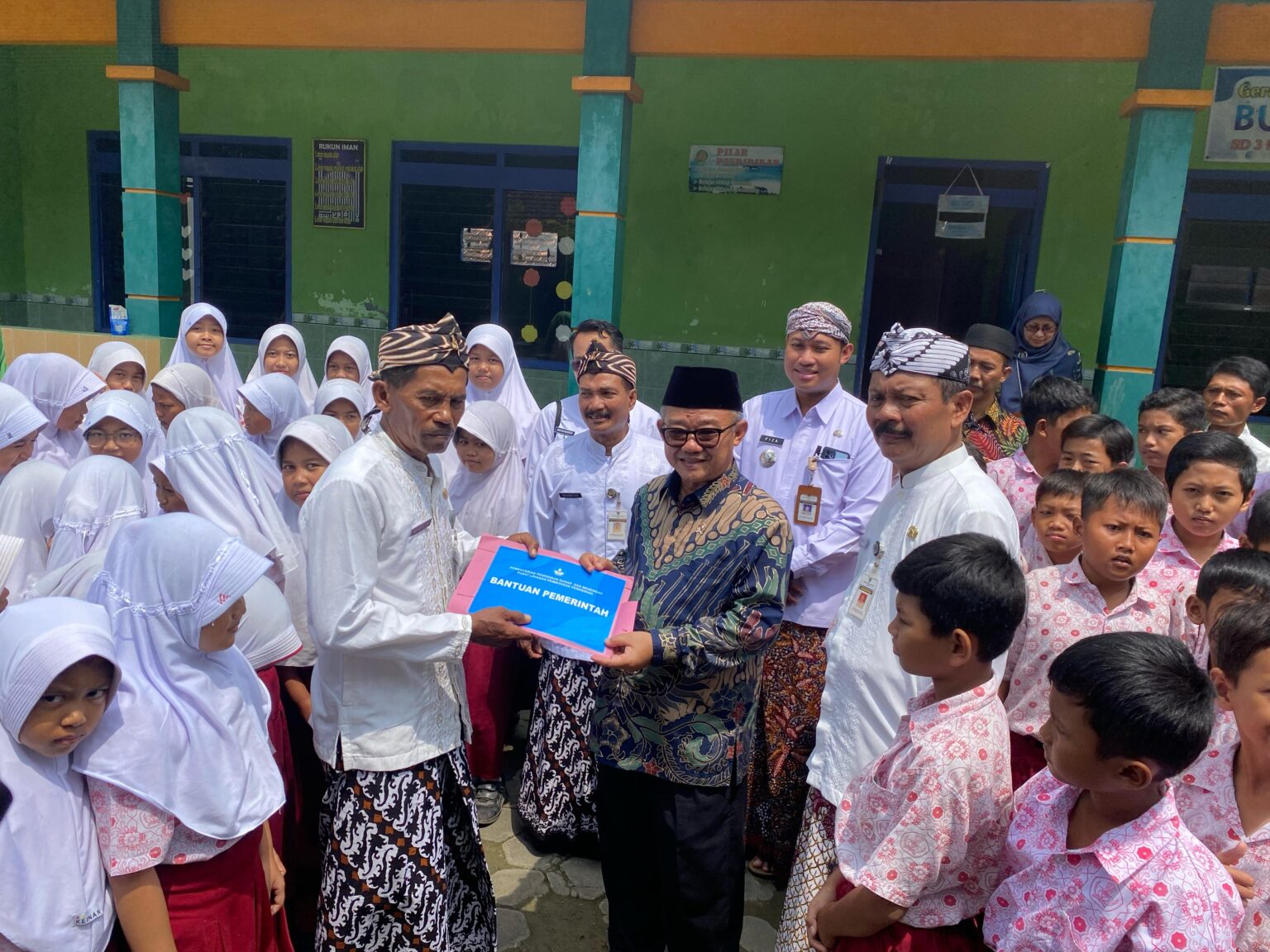 Mendikdasmen, Abdul Mu'ti, secara simbolis menyerahkan bantuan kepada sekolah terdampak banjir saat kunjungan di SDN 3 Pasuruhan Lor, Kudus pada Kamis (20/3/2025) (foto: Zonanews.id)