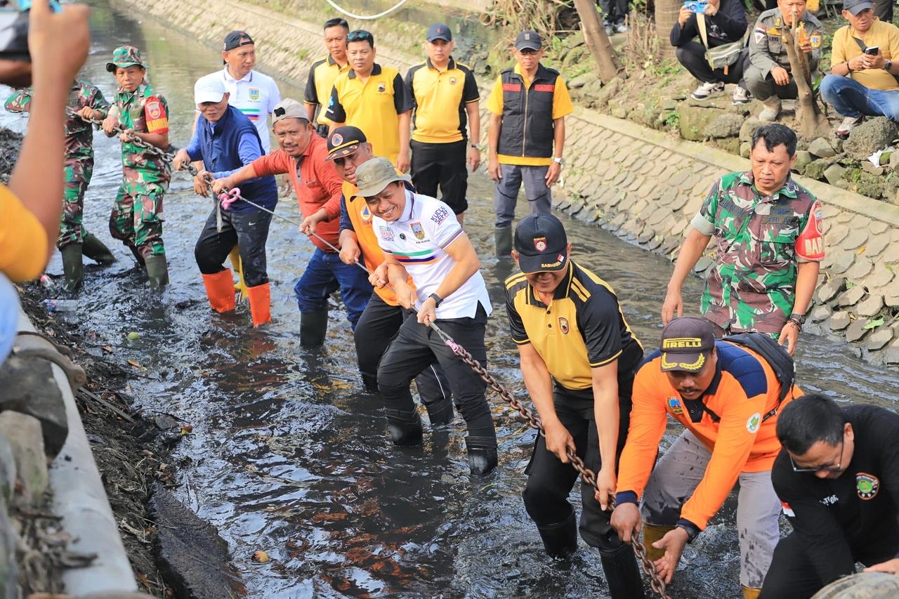 Bupati Kudus Sam'ani Intakoris gotong royong bersama jajaran, Polri, TNI, perwakilan puskesmas, Dinas PKPLH, BPBD, PUPR, dan para relawan membersihkan gorong-gorong di bawah Jalan Nasional Proliman, di Desa Tanjungkarang, Kecamatan Jati, Jumat (11/4/2025)