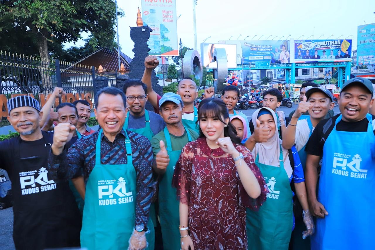 Bupati Kudus Sam'ani Intakoris dan Wakil Bupati Kudus Bellinda Birton bersama PKL yang mendapat bantuan celemek dan sarung tangan di kawasan Alun-Alun Simpang Tujuh Kudus pada Sabtu (26/4/2025)
