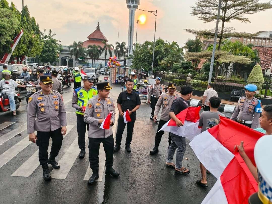 Polres Kudus membagikan 1.000 bendera Merah Putih kepada pengguna jalan di kawasan Alun-alun Simpang Tujuh Kudus, Selasa (5/8) sore