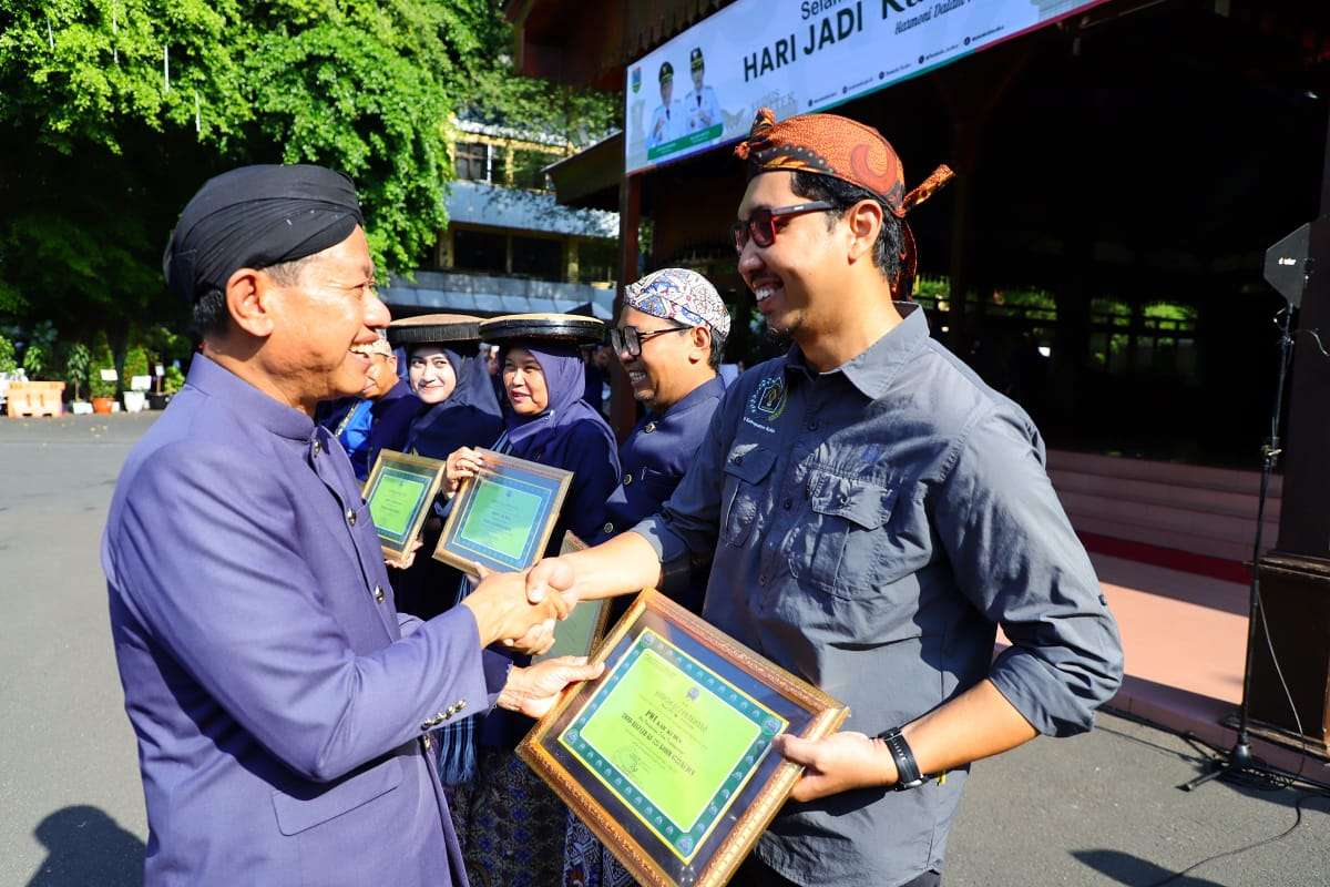 Penghargaan partisipasi TMMD diserahkan langsung oleh Bupati Kudus, Sam’ani Intakoris, kepada Ketua PWI Kudus, Saiful Annas, seusai upacara peringatan Hari Jadi ke-476 Kabupaten Kudus di Halaman Pendopo Kudus, Selasa (23/9/2025).
