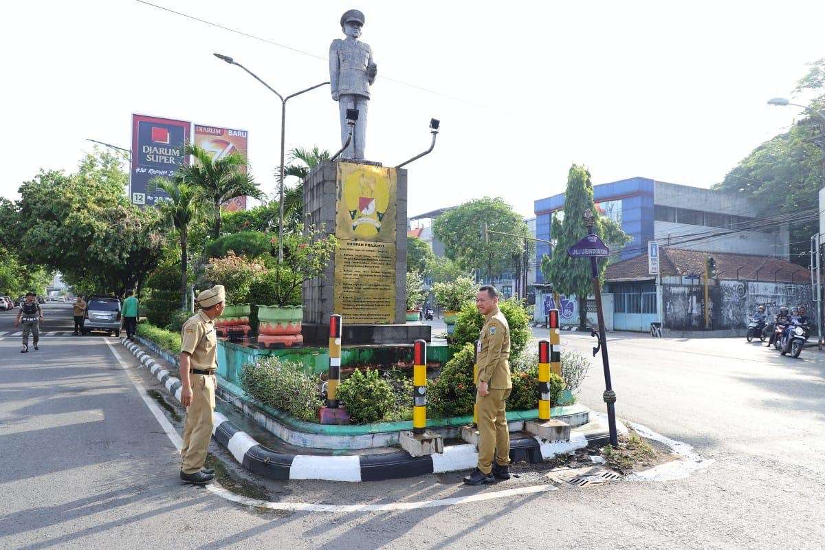 Bupati Kudus Sam'ani Intakoris melakukan bersih-bersih sambil meninjau Taman Tugu Jenderal Ahmad Yani di Jalan Ahmad Yani Kudus, Senin (29/9/2025)