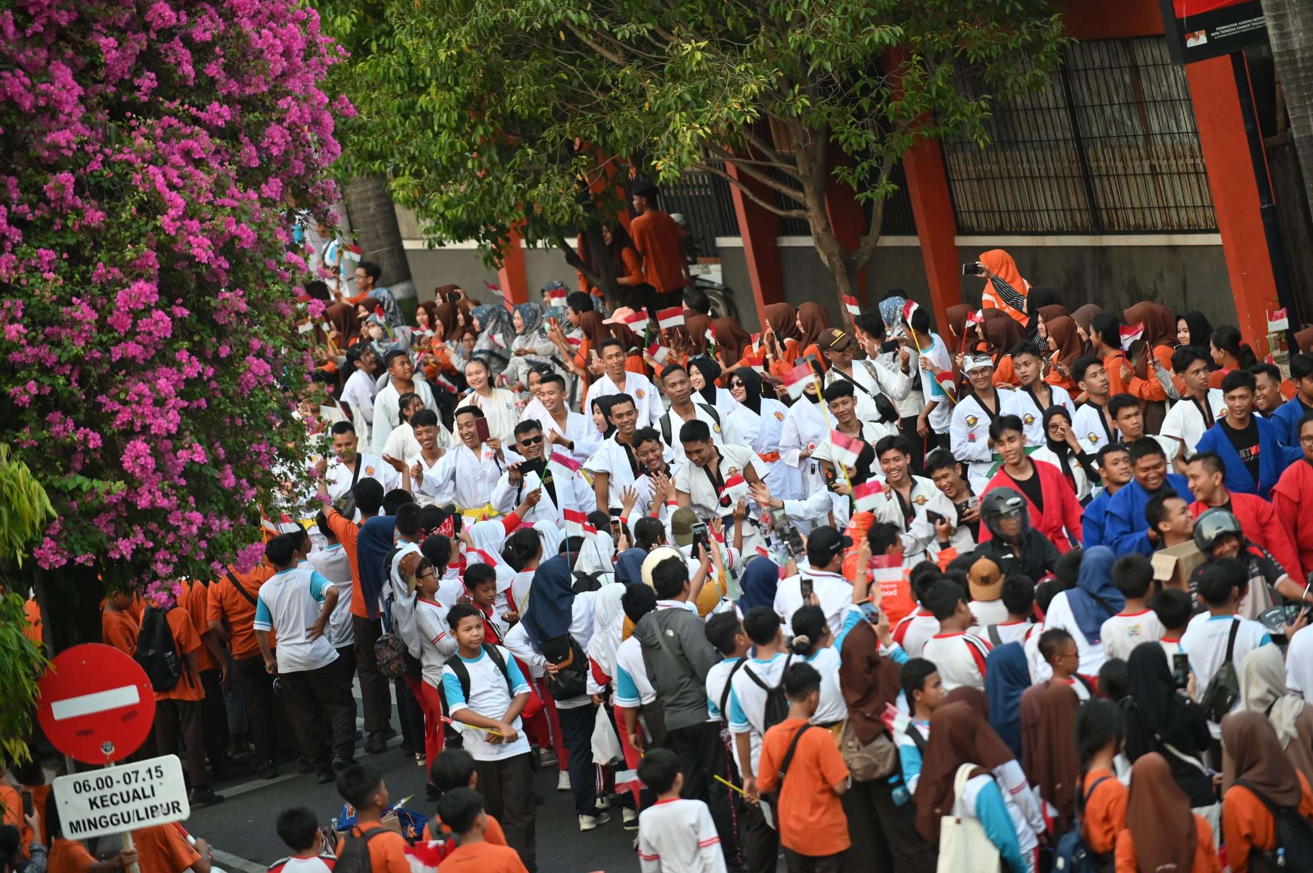 Ribuan anak sekolah dan masyarakat Kudus menyambut riuh kedatangan para perwakilan kontingen Pekan Olahraga Nasional (PON) Bela Diri Kudus 2025 yang berjalan menuju Alun-alun Simpang Tujuh Kudus, Sabtu (11/10/2025)
