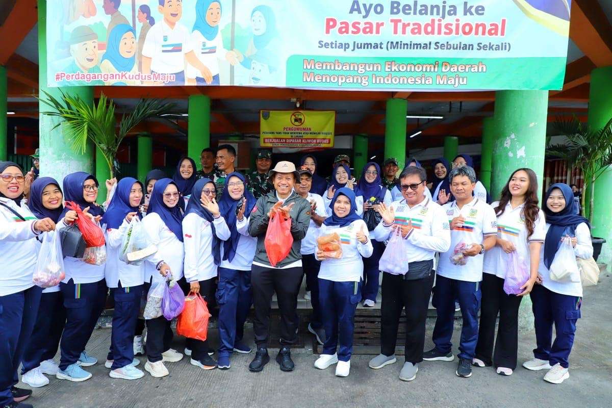 Bupati Kudus Sam'ani Intakoris berfoto bersama ASN usai nglarisi dagangan pedagang Pasar Kliwon pada Jumat (24/10) pagi